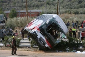 Firemen work at the site of a coach crash that has left at least 14 students dead at the AP-7 motorway in Freginals, in the province of Tarragona, northeastern Spain, 20 March 2016. The coach carrying dozens of Erasmus students collided with a car and overturned. The students from several different countries were heading to Barcelona after attending Las Fallas Festival in Valencia, eastern Spain. EPA/JAUME SELLART